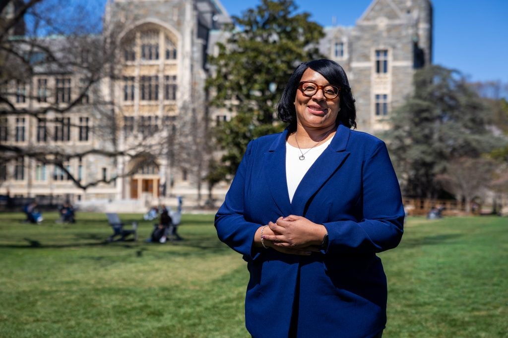 Black woman in blue suit smiling on Healy Lawn