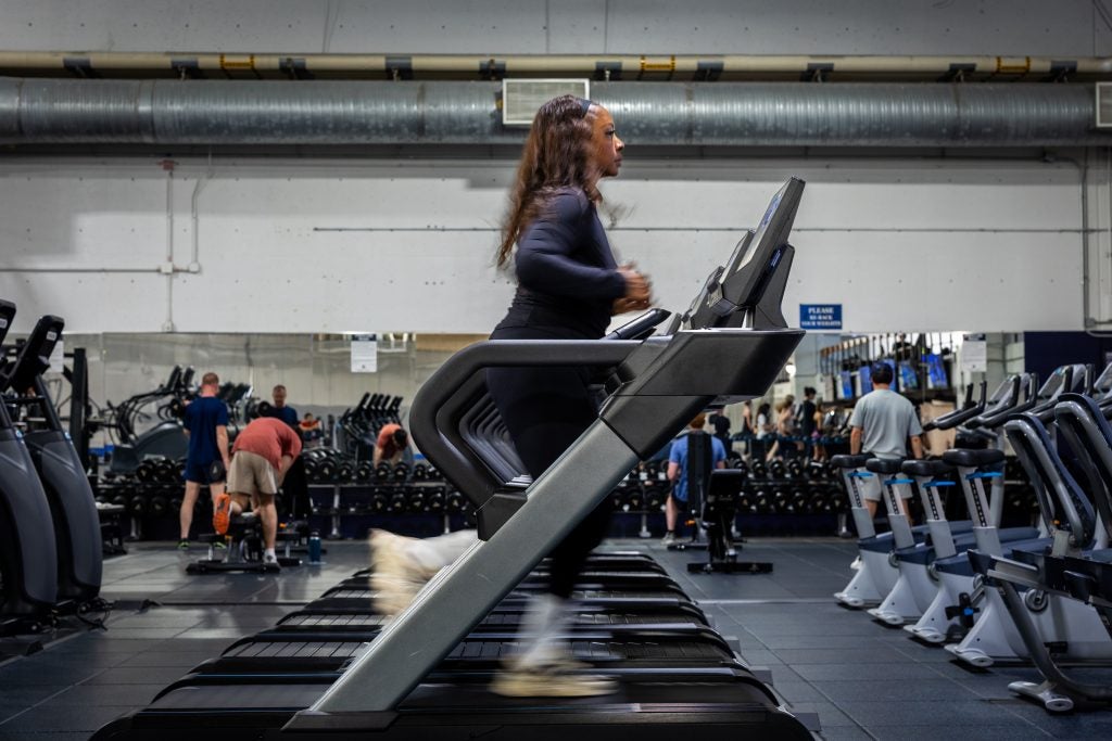A woman runs on a treadmill in a gym
