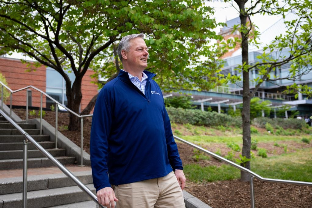 A man stares ahead while walking down a flight of stairs