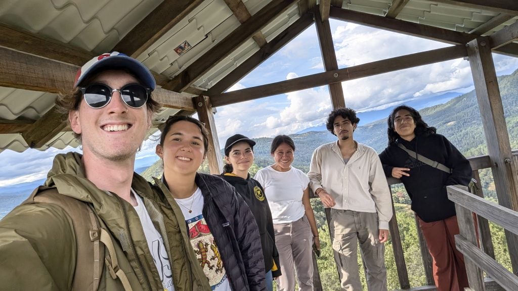 Six young people overlooking a hilly forest
