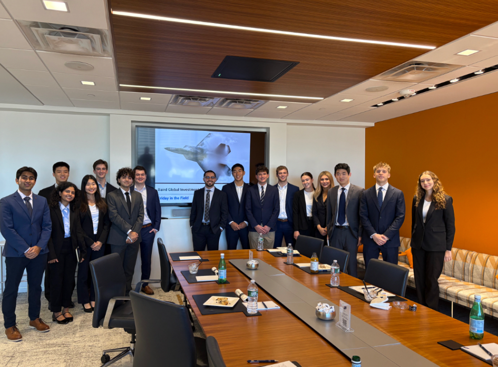 A group of students in a conference room wearing business attire