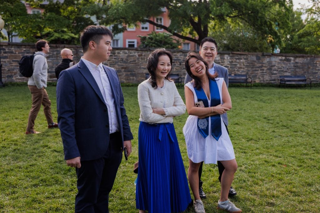 A family smiles on a lawn