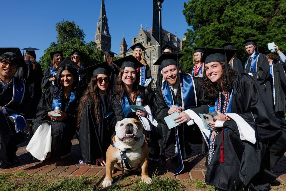 A group of graduates pose with Jack the Bulldog