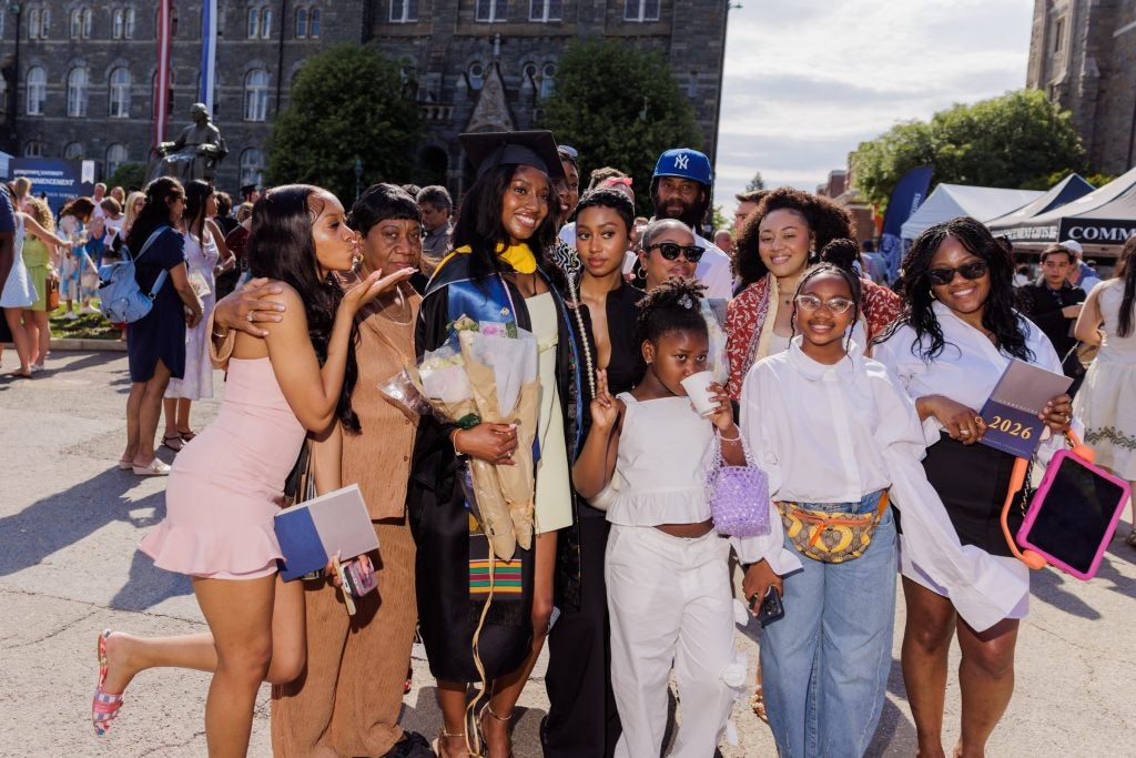 A female student poses for a photo with her family