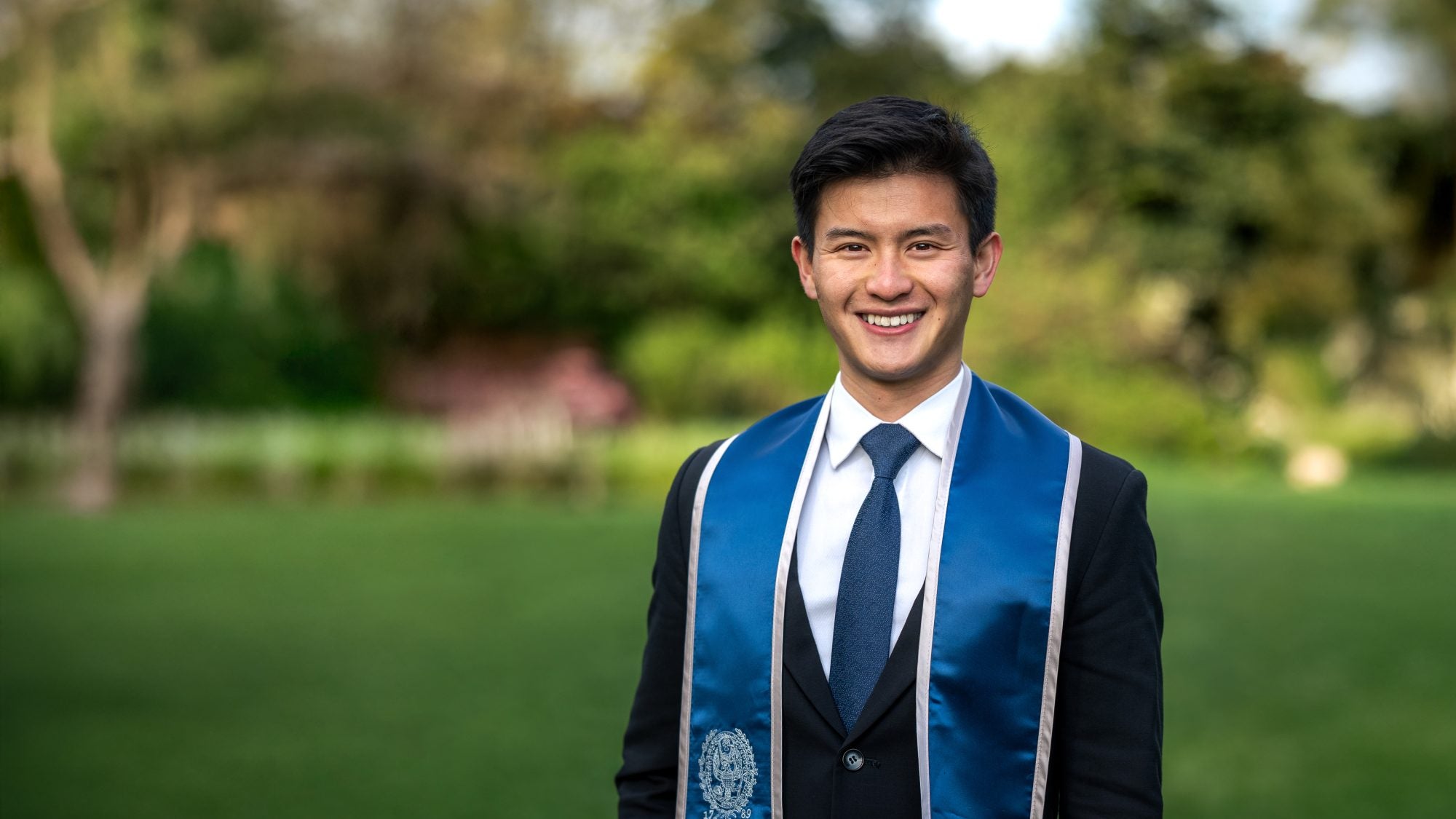 Young Asian college student in graduation regalia