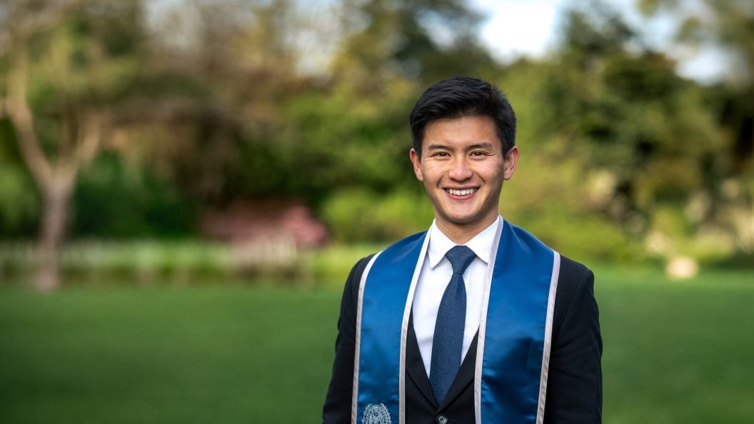 Young Asian college student in graduation regalia