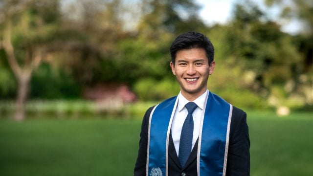 Young Asian college student in graduation regalia