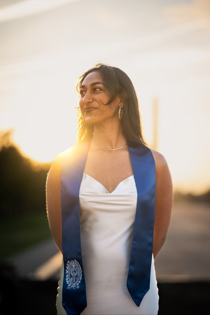 Young South Asian woman in white dress and a blue graduation stole