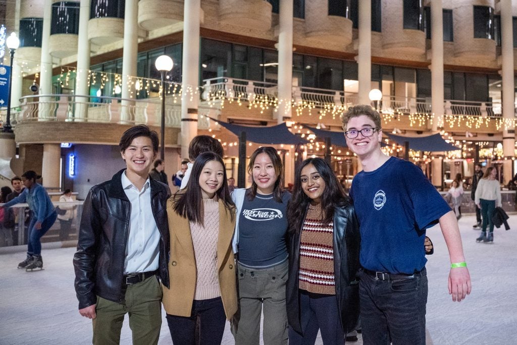 A group of five college students at an ice rink
