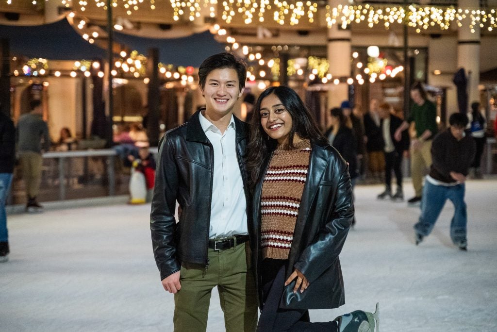 Two college students smiling at an ice rink