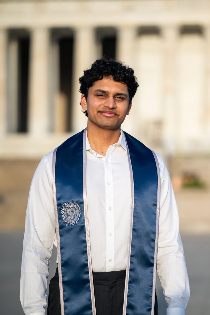 Young man wearing a white shirt and graduation stole