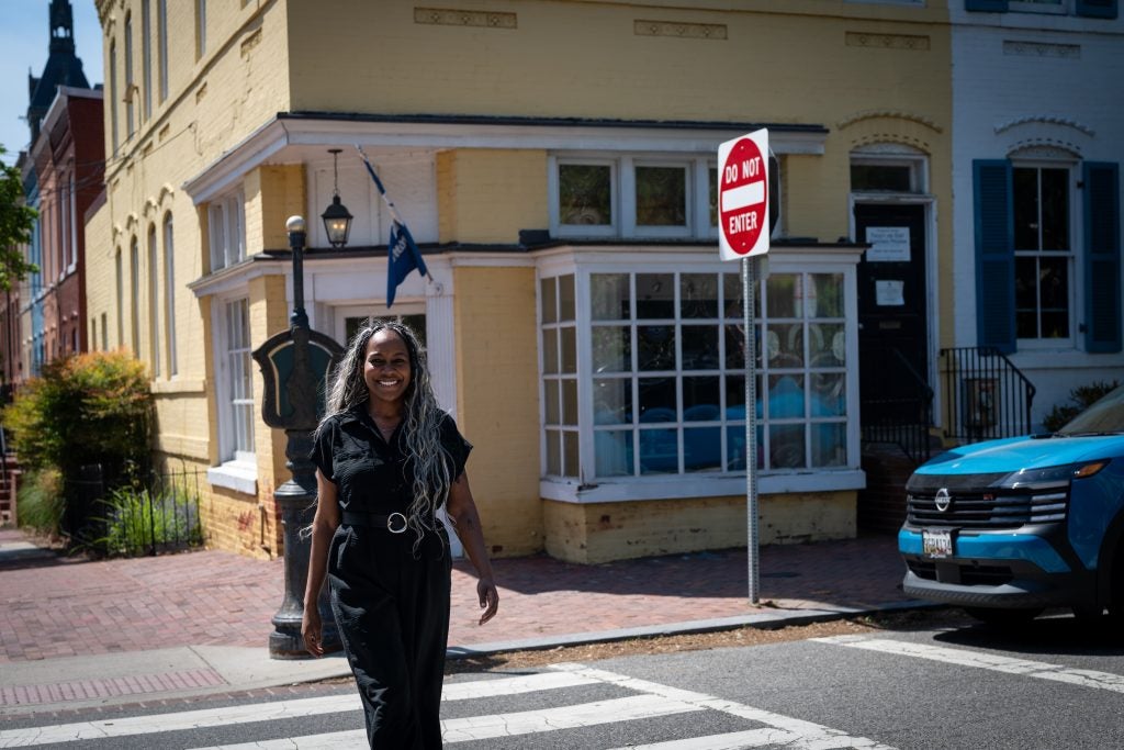 Black woman crossing street while smiling