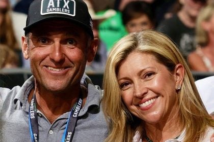 A husband and wife smile at a sports game