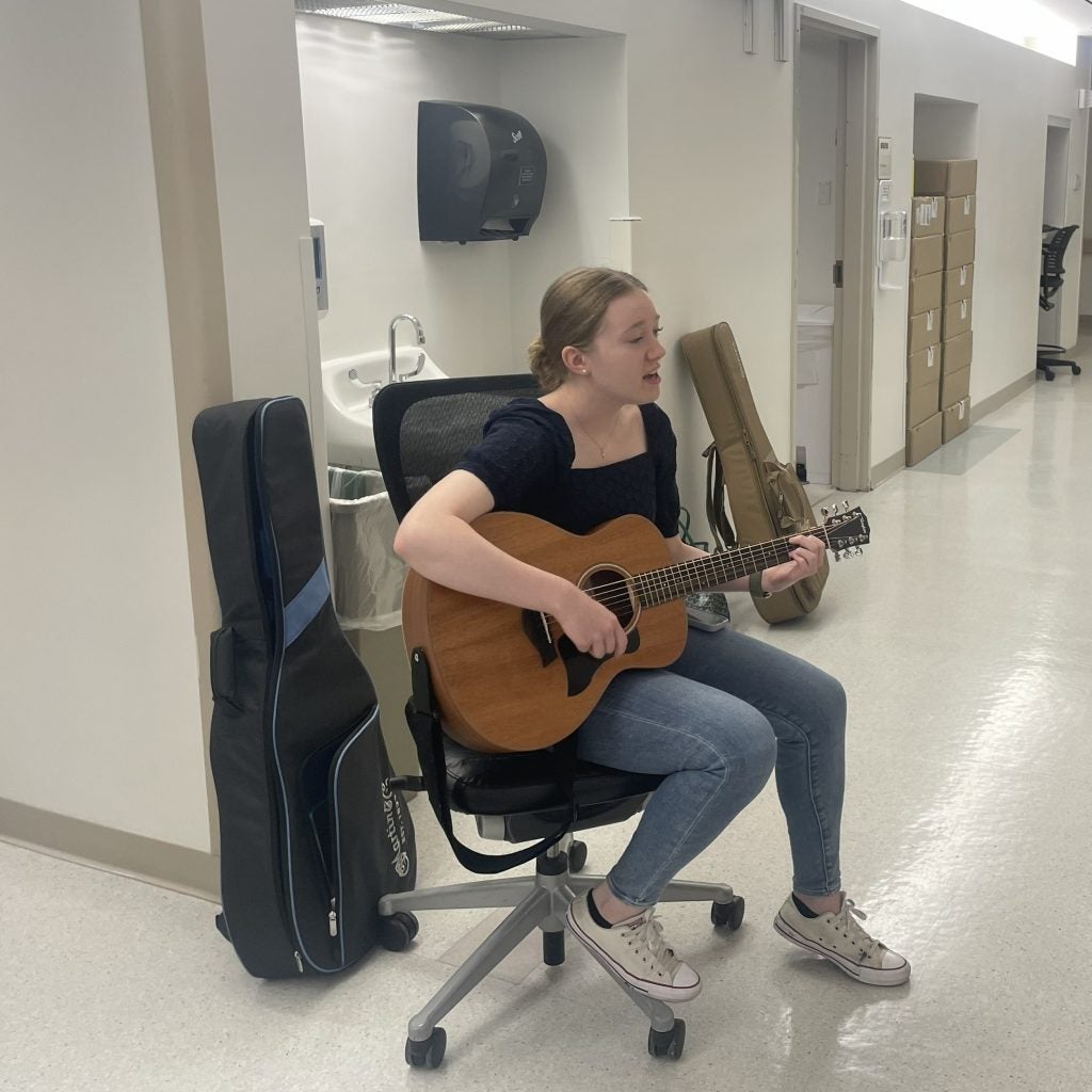 Young woman playing guitar in a hospital