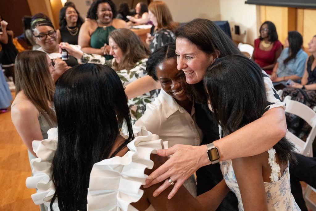 A woman hugs a group of nursing students