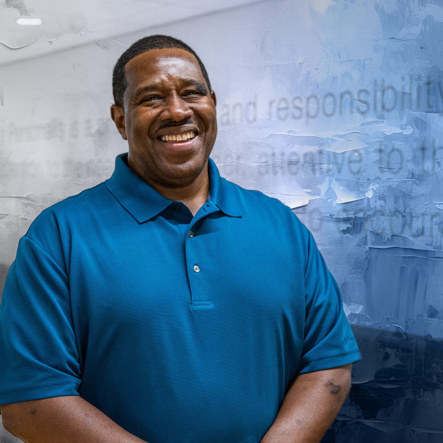 Black man in blue shirt smiling