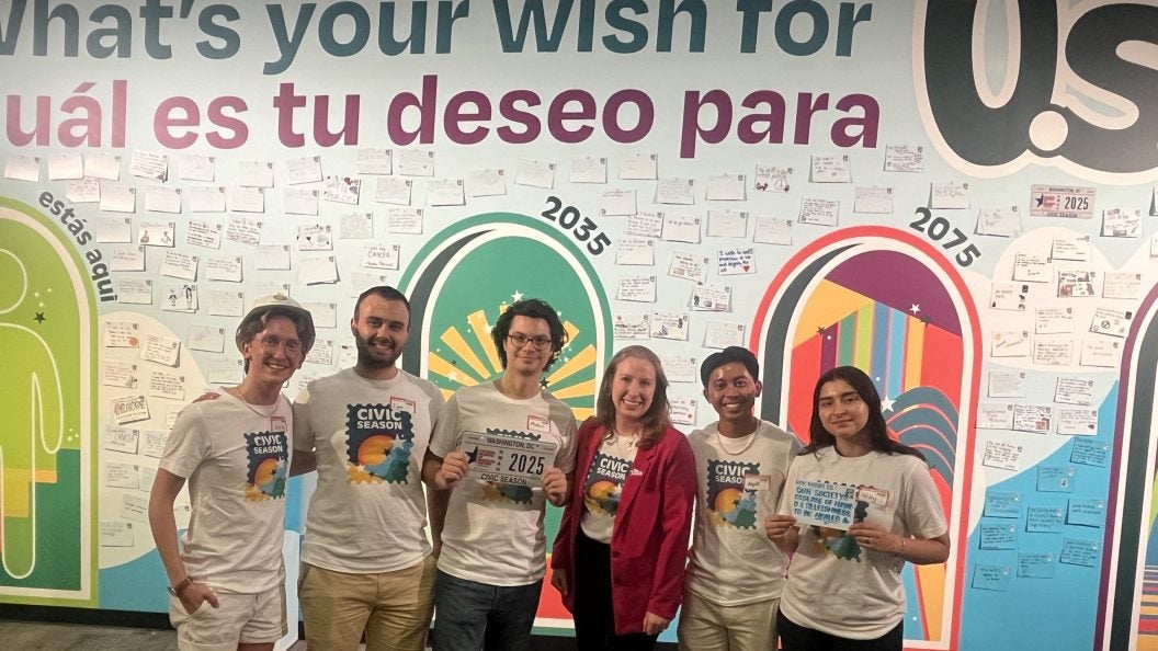 A group of young people stand in front of a handwritten wall