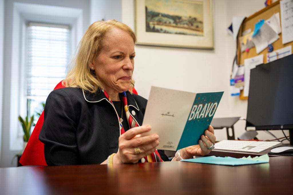 A woman smiles while reading a card that says, "Bravo!"