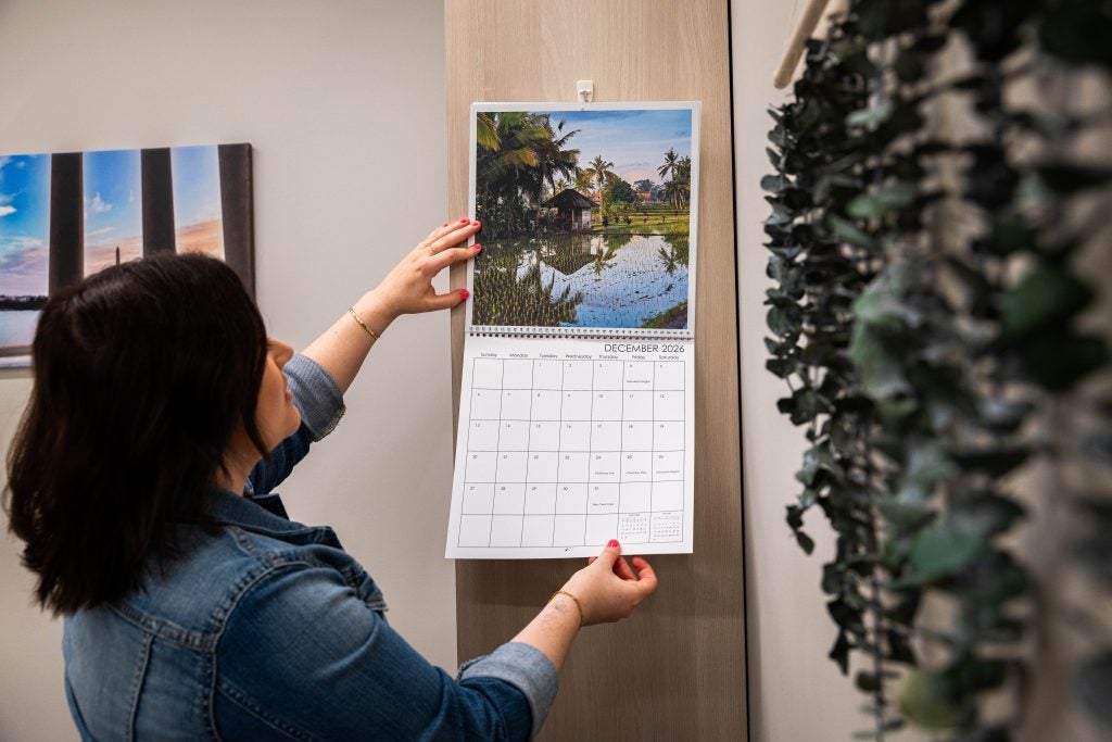 A woman holds onto a calendar in her office