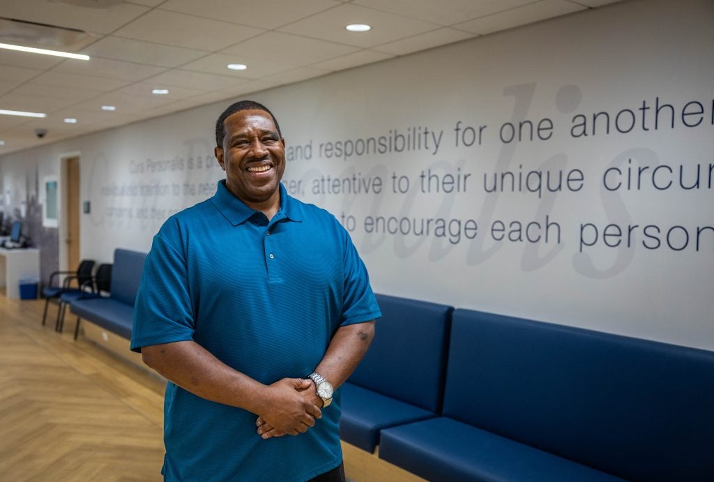 Black man in blue shirt smiling