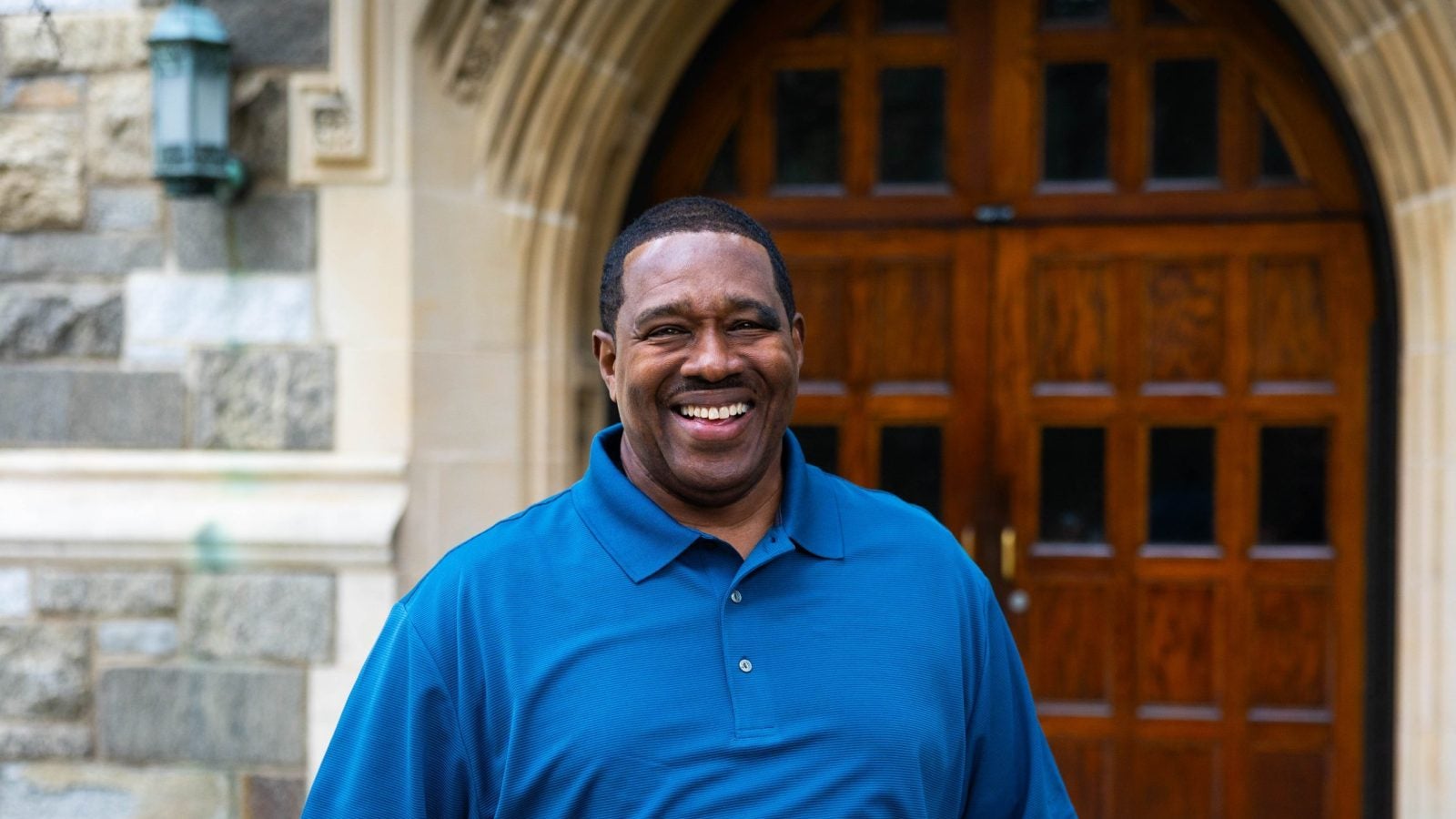 Black man in blue shirt smiling