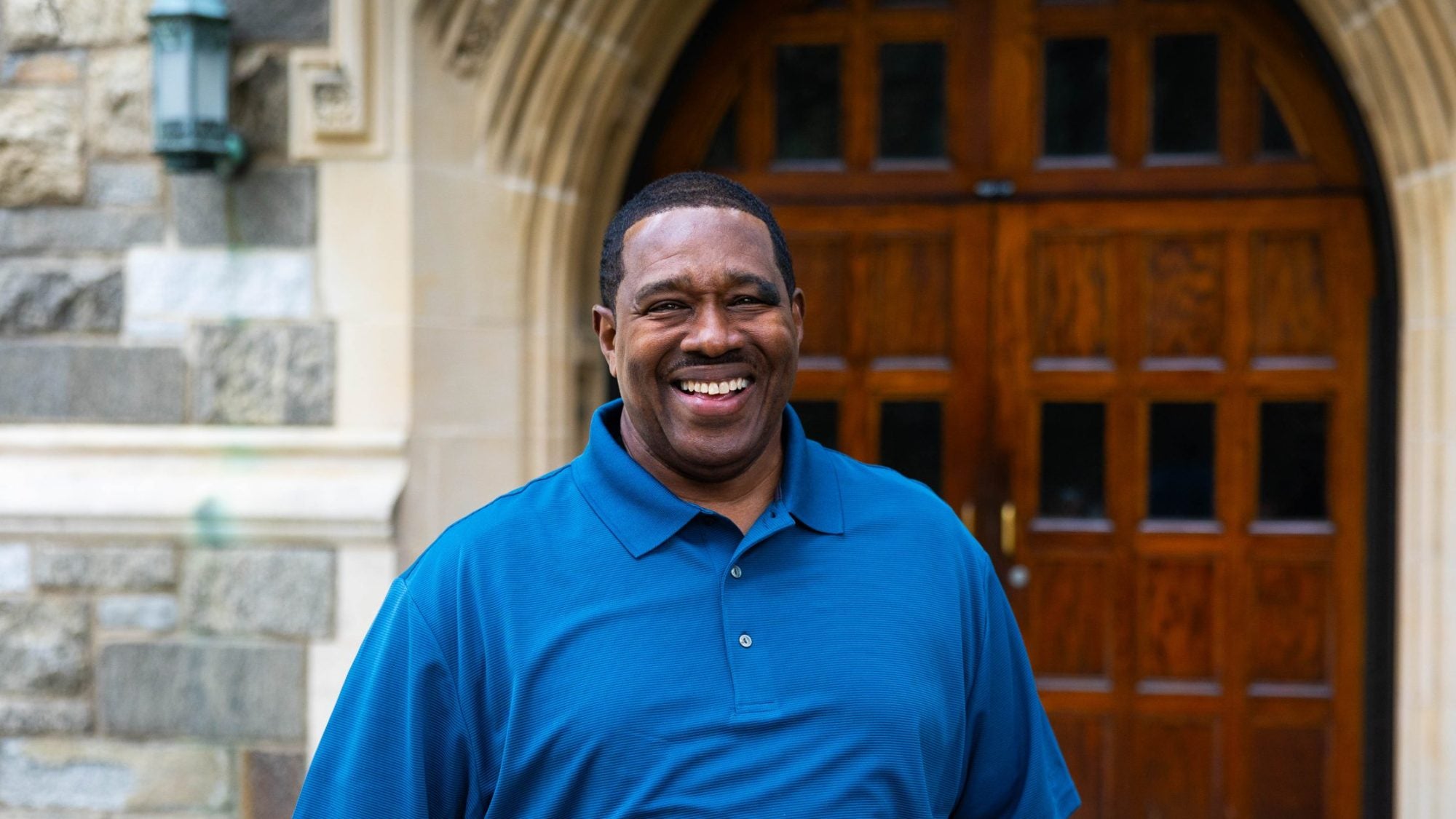 Black man in blue shirt smiling