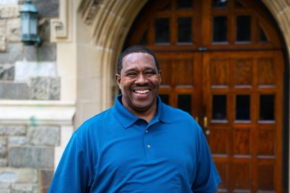 Black man in blue shirt smiling