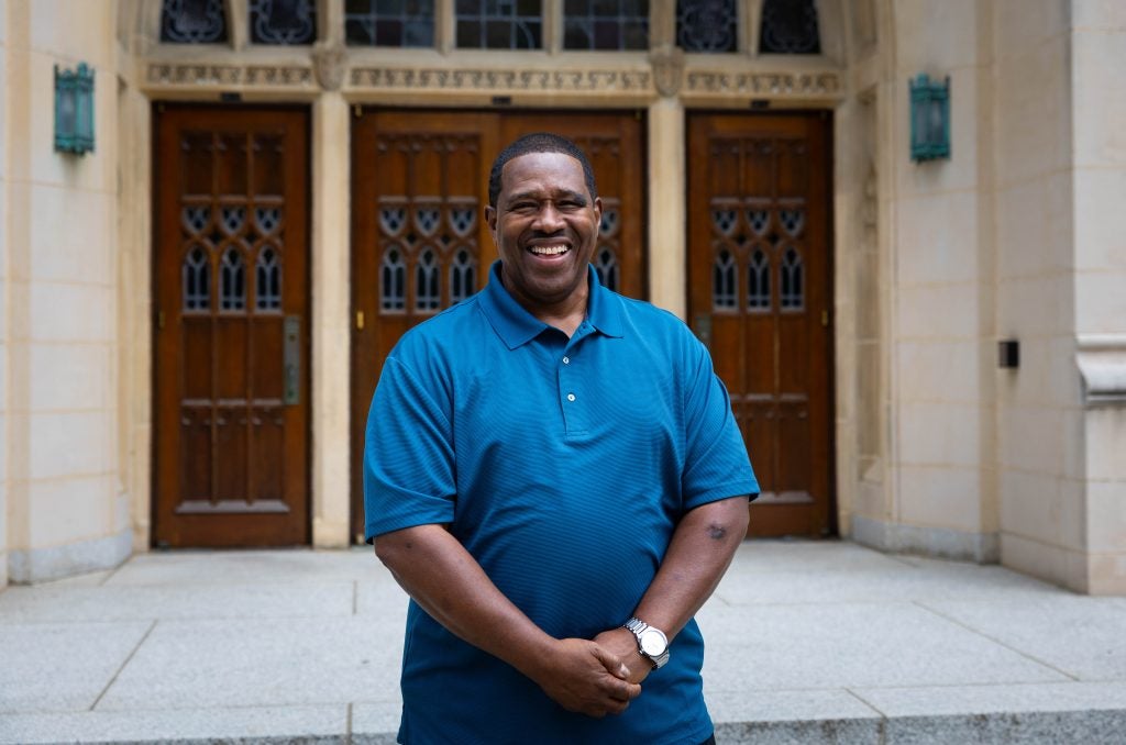 Black man in blue shirt smiling