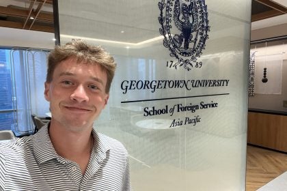 Young man smiling in a GU polo shirt