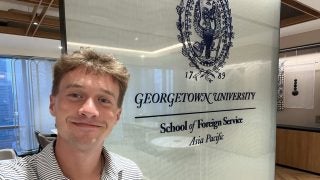 Young man smiling in a GU polo shirt
