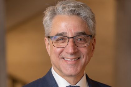 Man in a suit wearing glasses and smiling