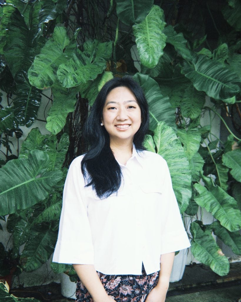 Portrait of young Asian woman in white blouse smiling