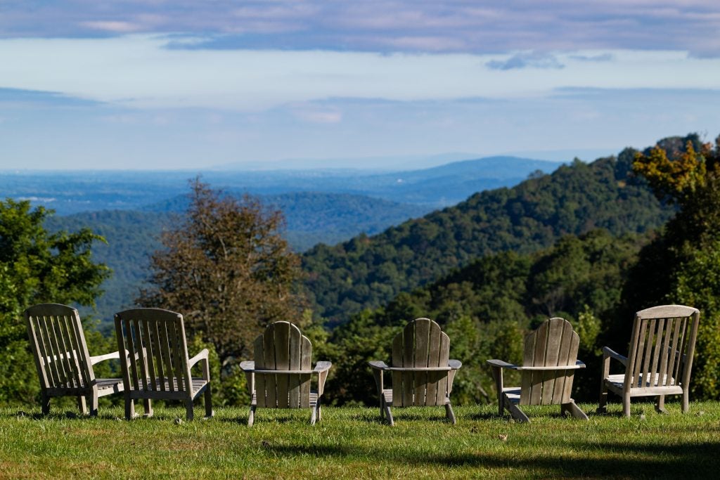 A line of chairs overlook mountains in Virginia on a sunny day