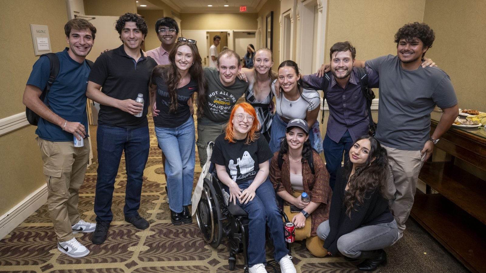 A diverse group of graduate students smiles toward the camera.