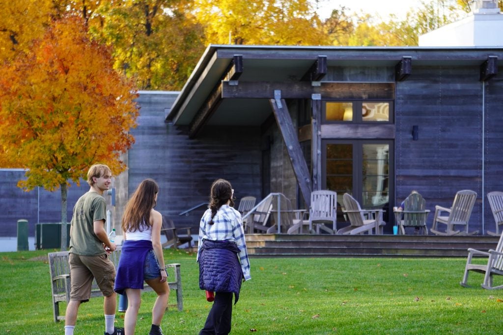 A group of students walk toward a retreat house in the fall