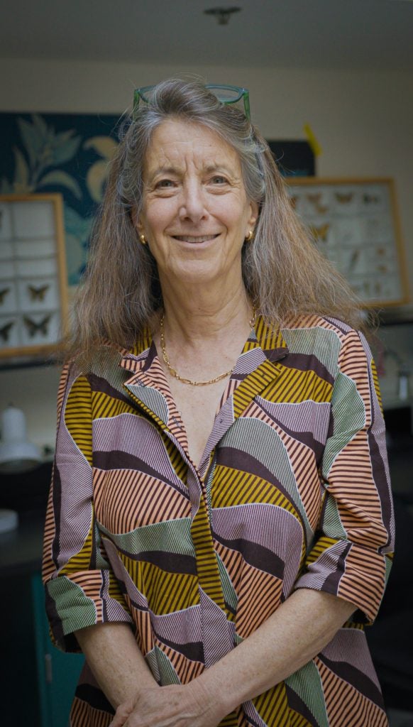 Caucasian woman with graying hair smiling in a biology lab