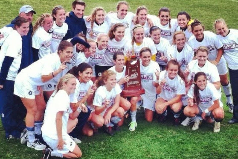 Female soccer team holding up a trophy