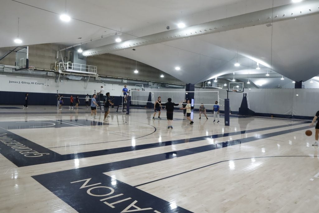Students playing volleyball indoors