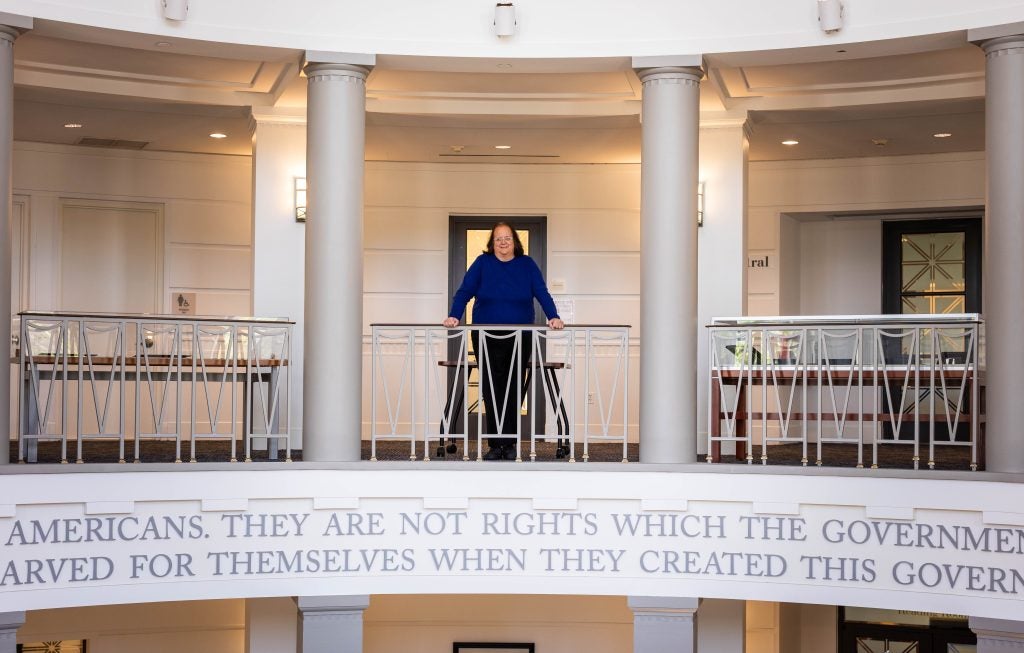 A woman gazes off the balcony of a library