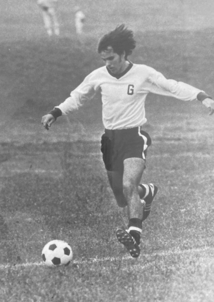 Black and white photo of young man playing soccer