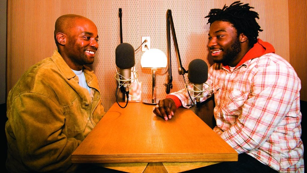 Two men interview each other in a recording studio