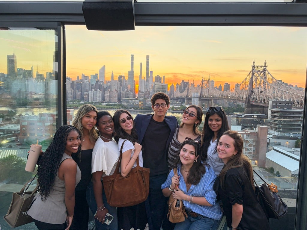 A group of young adults on a rooftop in New York during sunset