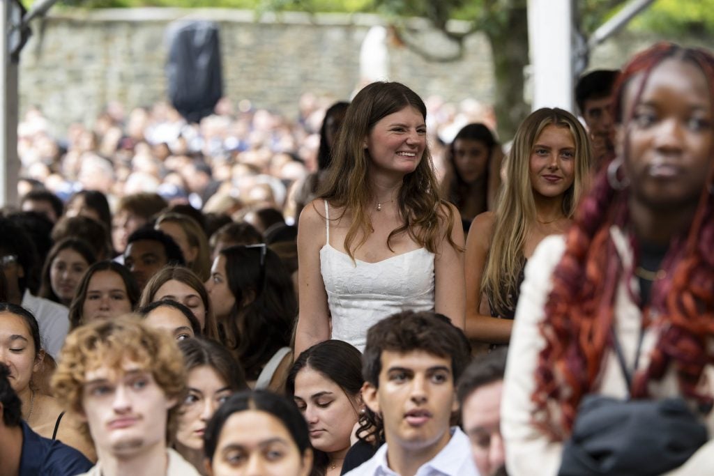 A student standing and smiling at New Student Convocation
