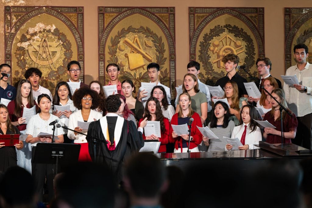 Students in a choir singing in Gaston Hall