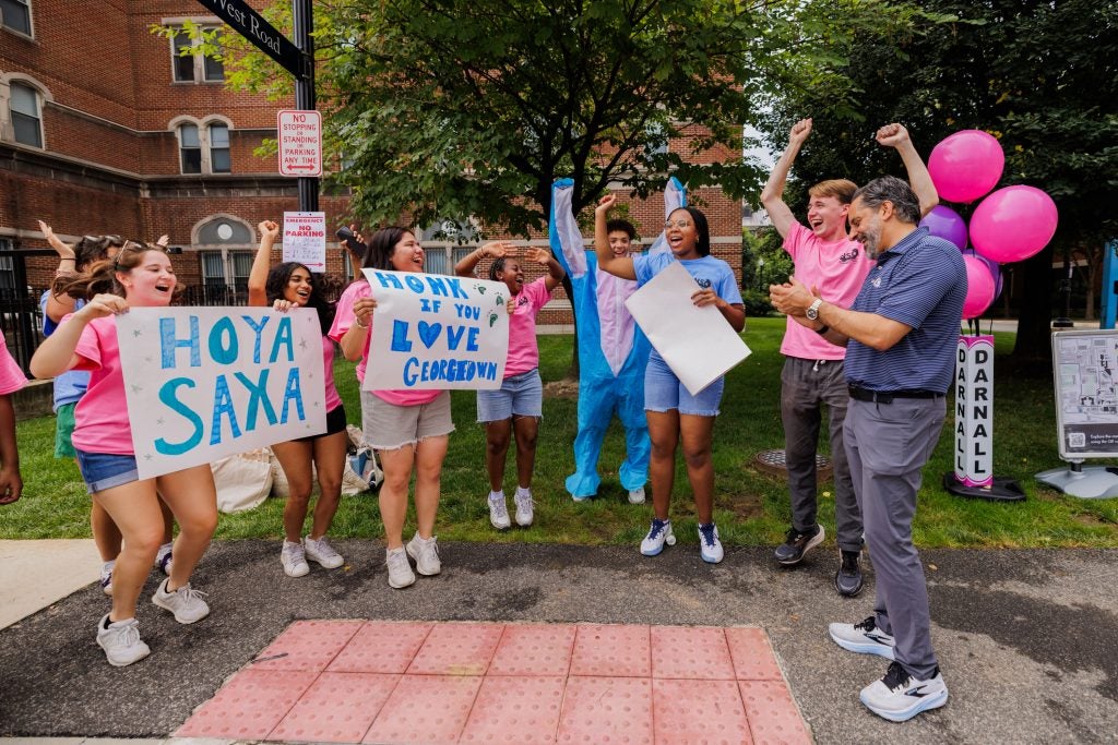 Students cheering with signs as Eduardo Peñalver claps