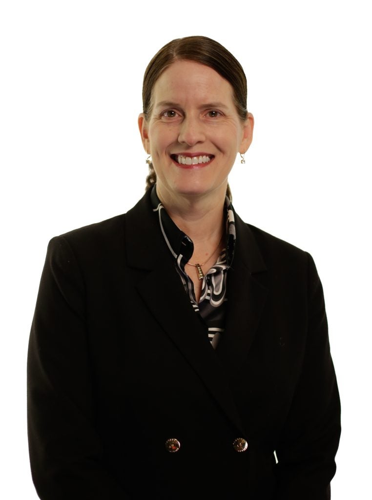 Caucasian woman in business attire smiling in a professional portrait