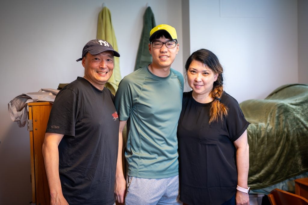 Young Asian man with his parents in his dorm room