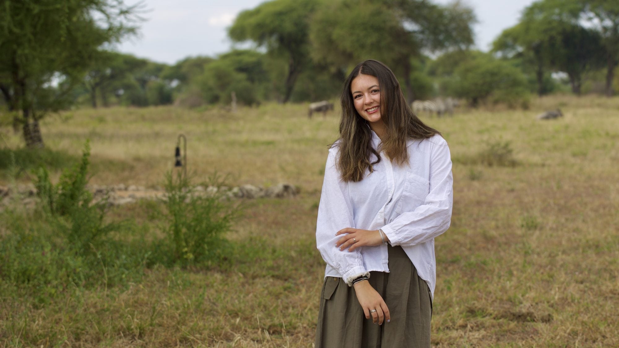 Young woman smiling while standing outside in a safari