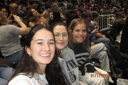 Three young women at a basketball game