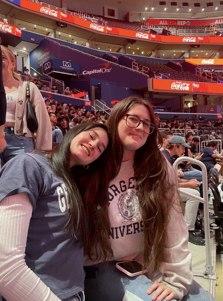 Two young women in a basketball stadium